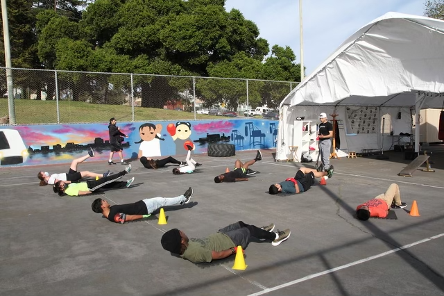 Dalia la Pantera with Vertical Skillz, Oakland youth stretching in San Antonio Park